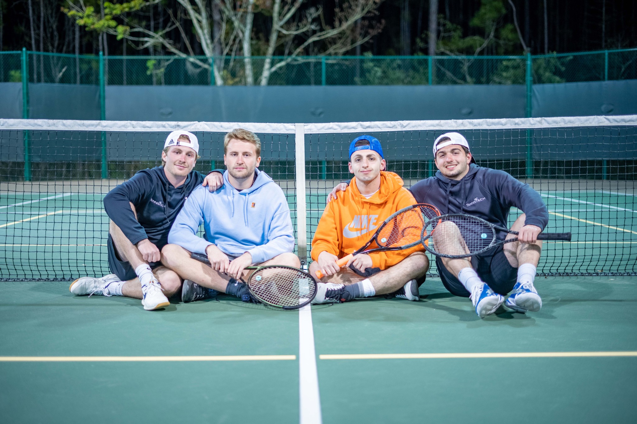 TennisTech coaches sitting on a tennis court